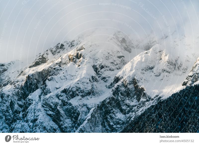 Snow covered alpine mountains with cloudy peaks at 'Mieminger Kette', Tirol, Austria snow winter fog white rock mieminger kette nature sun landscape sky travel