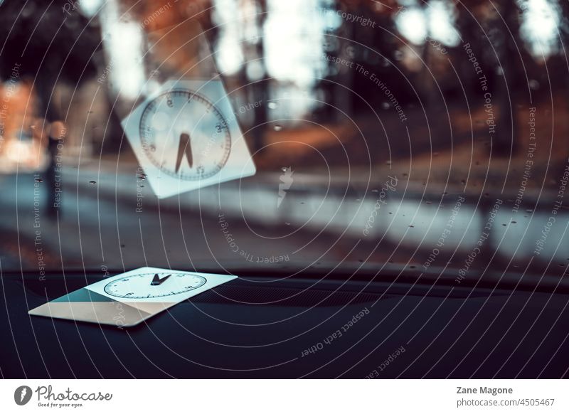 Parking clock on display behind the front windshield disc clock car autumn fall parking car parking Parking lot mood moody rain parking disc time hurry