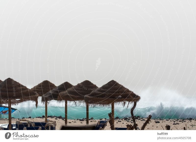 Parasols made of natural fibers on the beach from splashing spray summer longing Sunshade Beach bar White crest Waves Atlantic Ocean Atlantic coast vacation