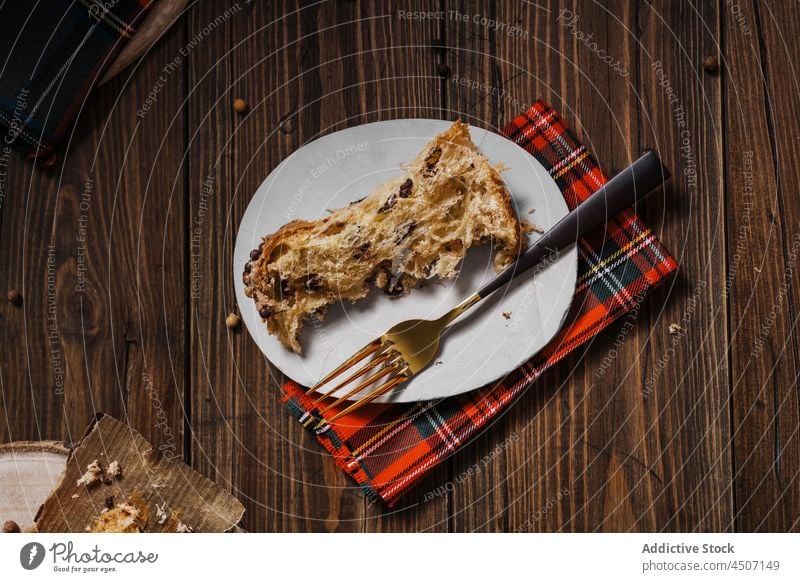 Plate with piece of baked dessert near fork panettone christmas homemade serve plate sweet tradition new year delicious italian pastry meal bread tasty