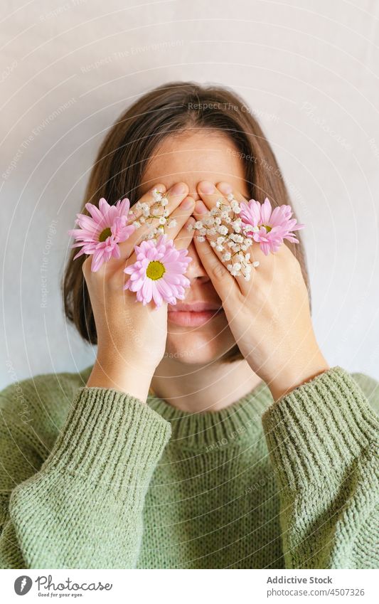 Woman covering face with blooming flowers woman bud chrysanthemum gypsophila hide delicate secret shy female tender gentle portrait plant cover eyes petal fresh