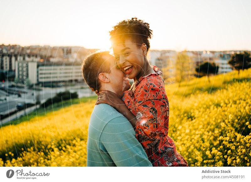 Romantic loving diverse couple kissing in nature on sunny day embrace love romantic date smile together hug relationship spend time picnic boyfriend girlfriend