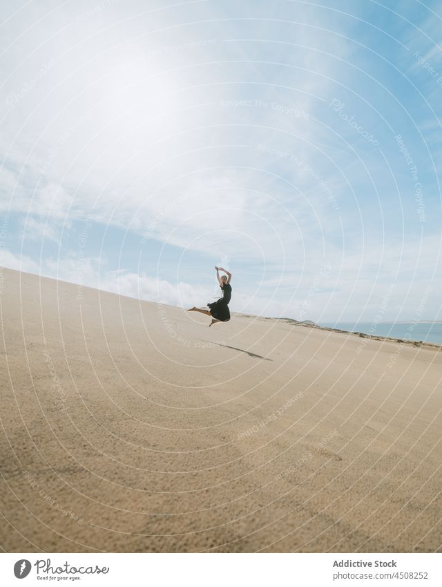 Graceful woman dancing in sandy desert dancer dune jumping move grace posture flexible female leg raised motion stretch perform freedom ballet barefoot balance