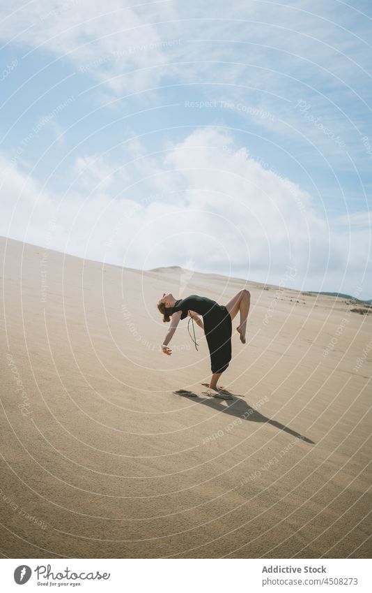 Graceful woman dancing in sandy desert dancer dune move grace posture flexible female leg raised motion stretch perform freedom ballet barefoot balance feminine