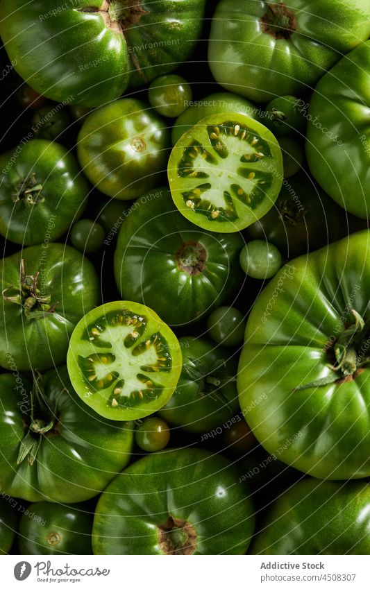 Sliced tomato on a pile of unripe tomatoes cherry tomato scatter slice vegetable harvest vitamin many countryside agriculture agronomy garden farm