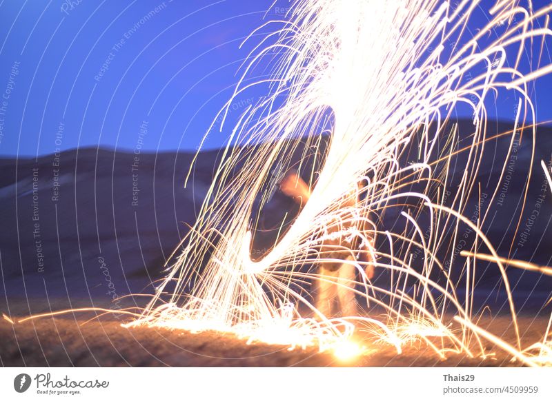 Iron wool circle drawing light fireworks. Burning Steel Wool spinning, Trajectories of burning sparks at night. Movement light effect, steel wool fire hoop. long exposure light painting, Pyrotechnic