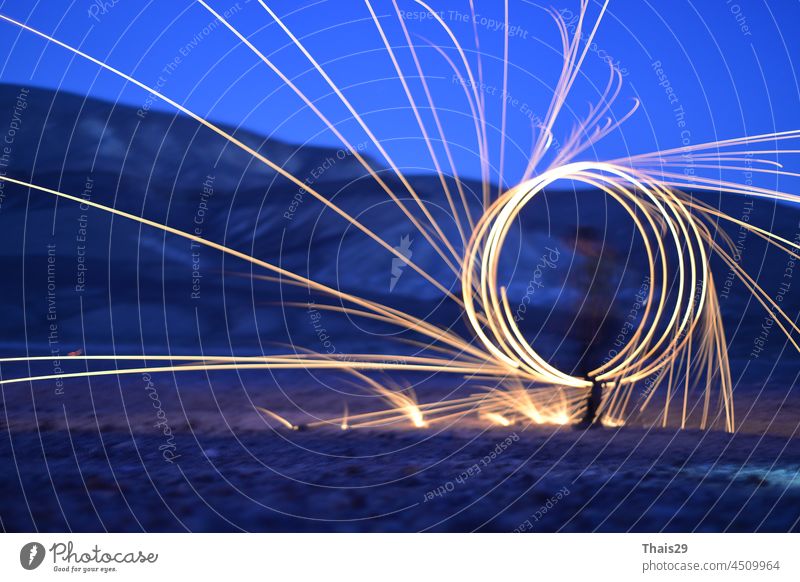 Iron wool circle drawing light fireworks. Burning Steel Wool spinning, Trajectories of burning sparks at night. Movement light effect, steel wool fire hoop. long exposure light painting, Pyrotechnic