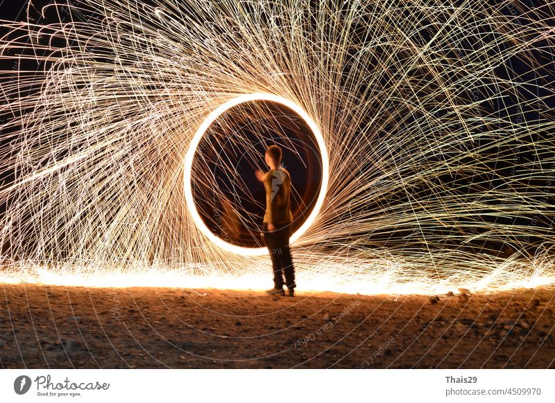 Iron wool circle drawing light fireworks. Burning Steel Wool spinning, Trajectories of burning sparks at night. Movement light effect, steel wool fire hoop. long exposure light painting, Pyrotechnic