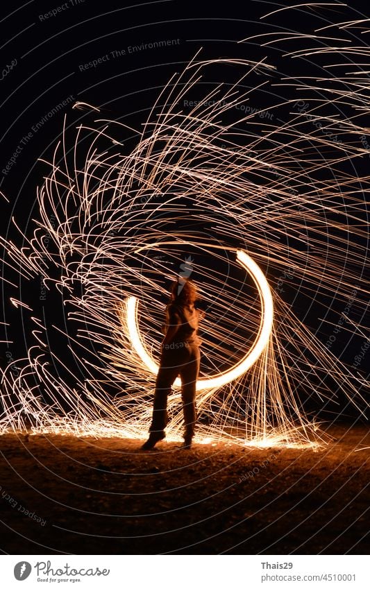 Iron wool circle drawing light fireworks. Burning Steel Wool spinning, Trajectories of burning sparks at night. Movement light effect, steel wool fire hoop. long exposure light painting, Pyrotechnic