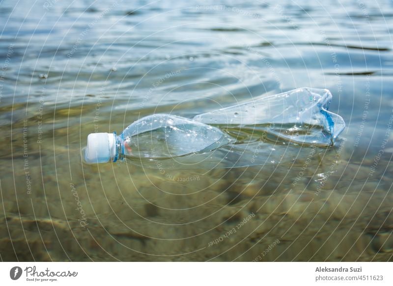 Used plastic bottle floating in clear water. Global environmental problem of plastic pollution on planet. Plastic waste in ocean. background blue climate coast