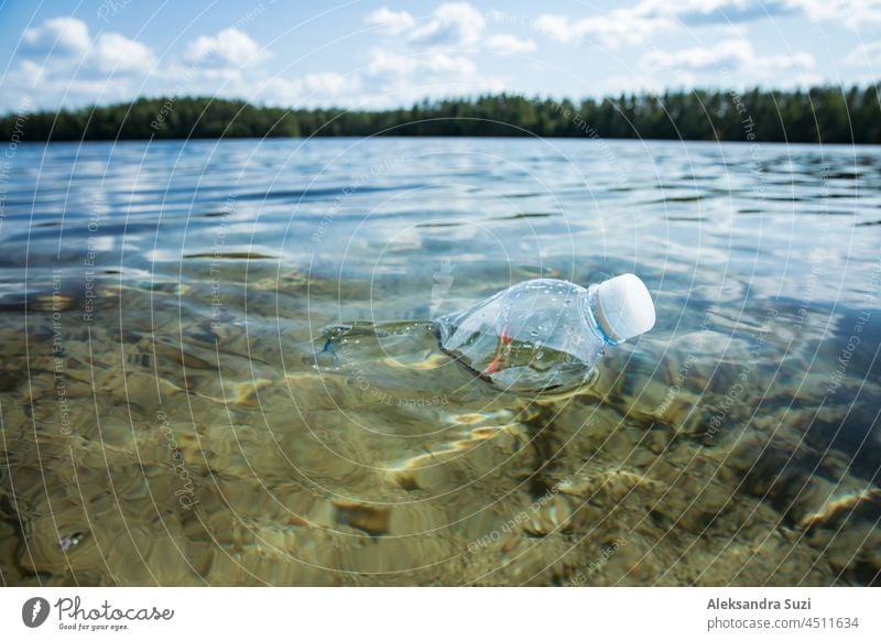 Used plastic bottle floating in clear water. Global environmental problem of plastic pollution on planet. Plastic waste in ocean. background blue climate coast