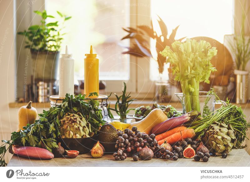 Various groceries at window background: Grapes, carrots, artichoke, avocado, figs and pumpkins. Sustainable lifestyle with unpacked healthy vegetables and fruits. Front view.