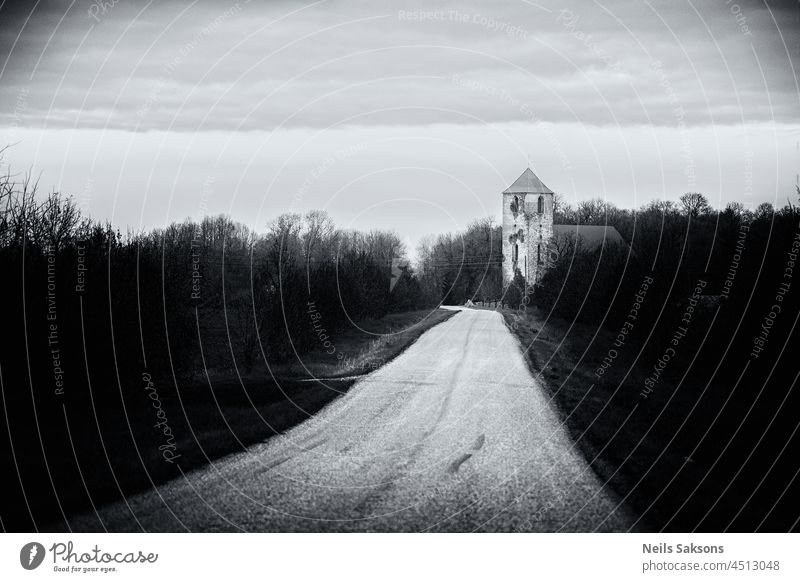 old church on road side, dark gloomy black and white. Bright country road, perspective, vignette architecture background baltic beautiful beauty blue building