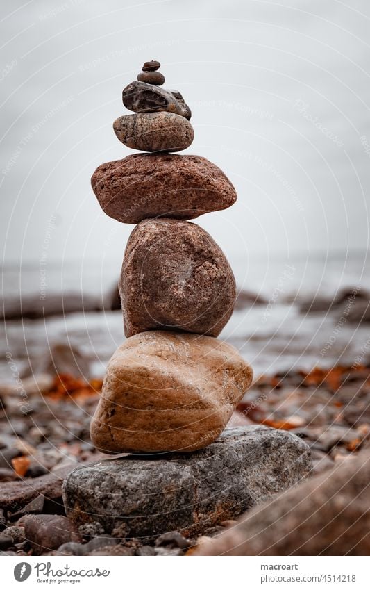 Stacked stones at the water Stacking stones stacked rocks stone coast Baltic Sea Ocean Body of water Water Beach Tall stackable Ascending Red Autumn leaves Sky