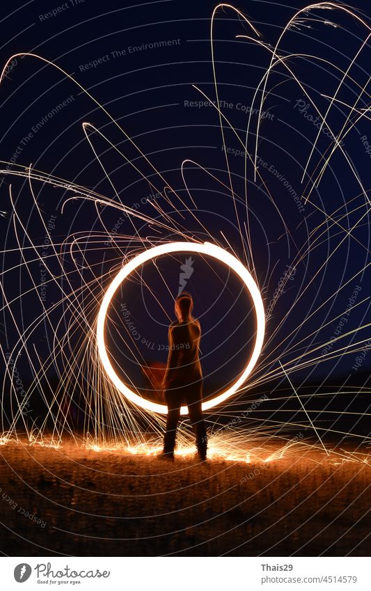 Iron wool circle drawing light fireworks. Burning Steel Wool spinning, Trajectories of burning sparks at night. Movement light effect, steel wool fire hoop. long exposure light painting, Pyrotechnic