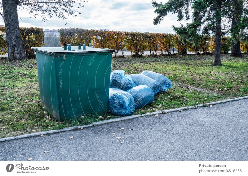 Garbage Container and Big pile of garbage in blue bags in the Park removal trash junk bin building bunch clean construction construction waste debris disposal