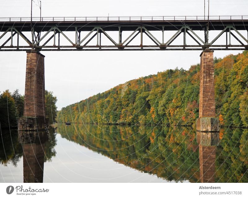 Railway bridge over the Fulda with smooth water the autumn trees are reflected in the water Bridge River Autumn reflection via the Fulda River water mirror