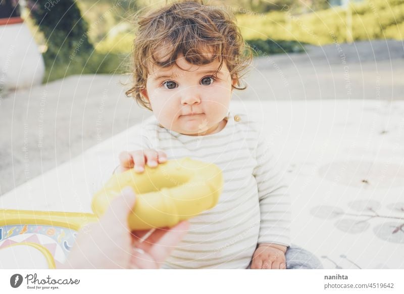 Little baby enjoying the day playing with her toys playful babyhood parenthood toddler happy happiness kindergarten outdoors nature natural candid real people