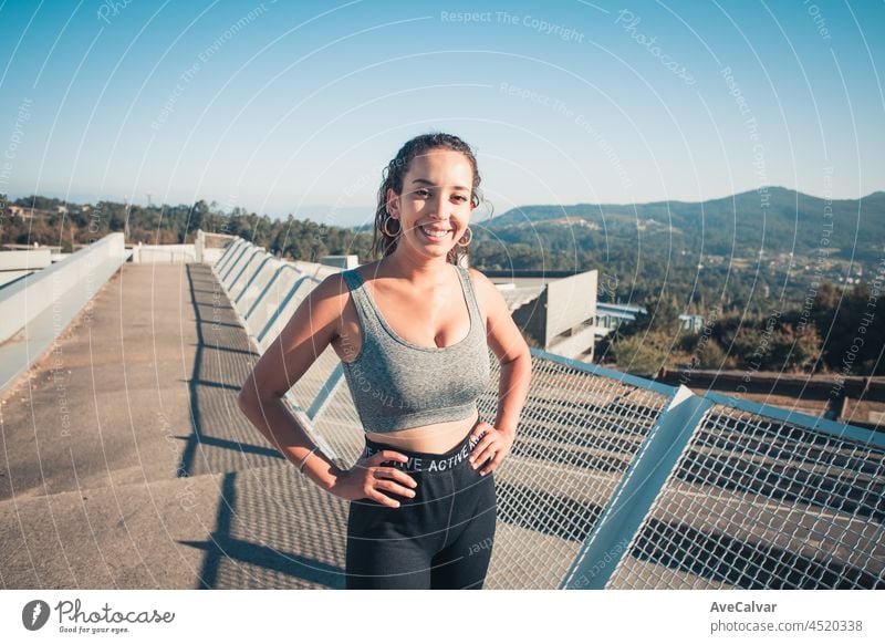 Young african woman smiling to camera while doing exercise, urban style image, sport and activities in the city, copy space young fitness athlete young adult