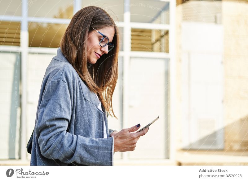 Focused businesswoman watching tablet on street entrepreneur using surfing online job busy female gadget eyeglasses device employee project manager internet