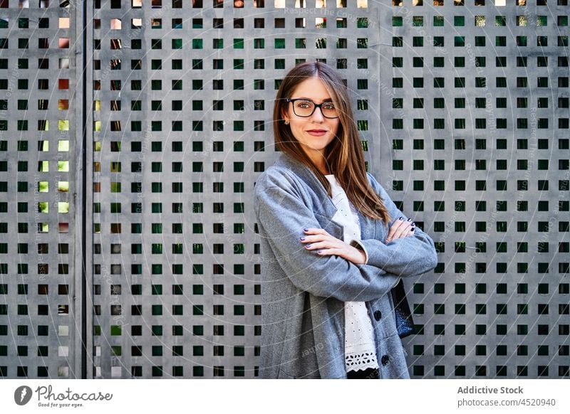 Smiling woman in formal wear standing near fence worker confident well dressed posture individuality appearance style positive professional female businesswoman