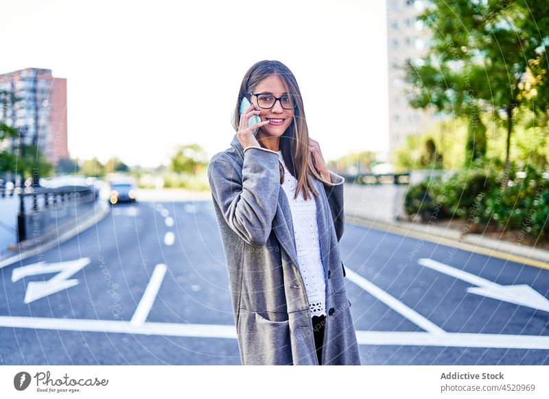 Smiling businesswoman talking on smartphone while crossing the street entrepreneur using phone call positive formal conversation work female connection speak