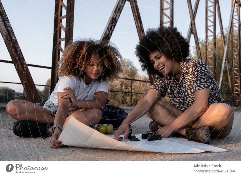 Black mother and daughter making route on map point direction bridge guide explore hike women traveler abandoned hiker adventure navigate nature journey