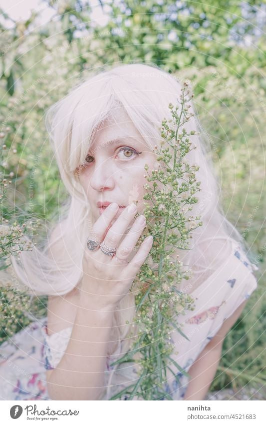 Artistic and reamy portrait of a woman surrouded by nature forest fantasy fairy delicate albino fairy tale feminine femininity long hair white caucasian pale