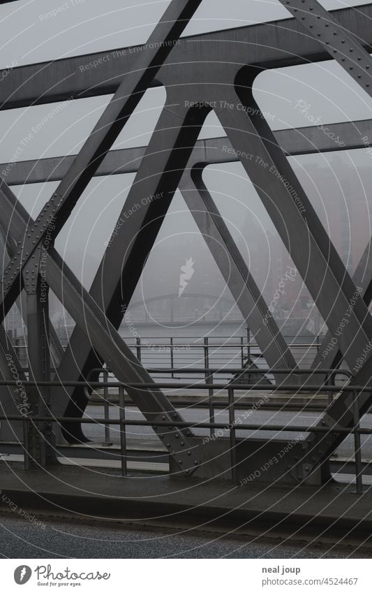 View through the iron struts of a harbour bridge to other bridges in the foggy background Hamburg Bridges Harbour iron construction structure vintage Industry