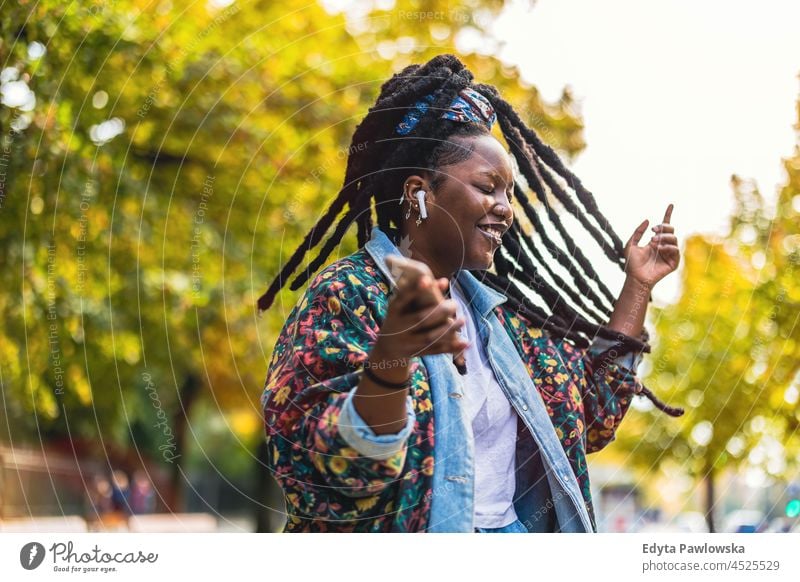 Young woman enjoying dancing and listening music outdoors unaltered natural real people authentic body inclusivity body positive one person hipster girl