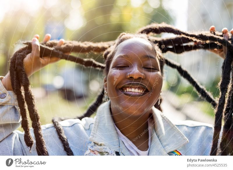 Attractive young woman playing with her hair outdoors unaltered natural real people authentic body inclusivity body positive one person hipster girl hairstyle