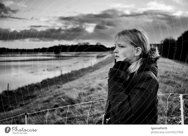 Child views flood from dike Water Flood contemplating Meditative Dike Deluge River Exterior shot High tide inundation floodplain windy Ems Emsland