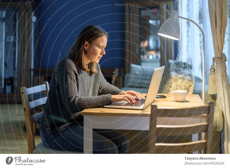 Woman working on laptop at home woman computer sitting lifestyle businesswoman typing person female indoor internet technology adult using wireless table