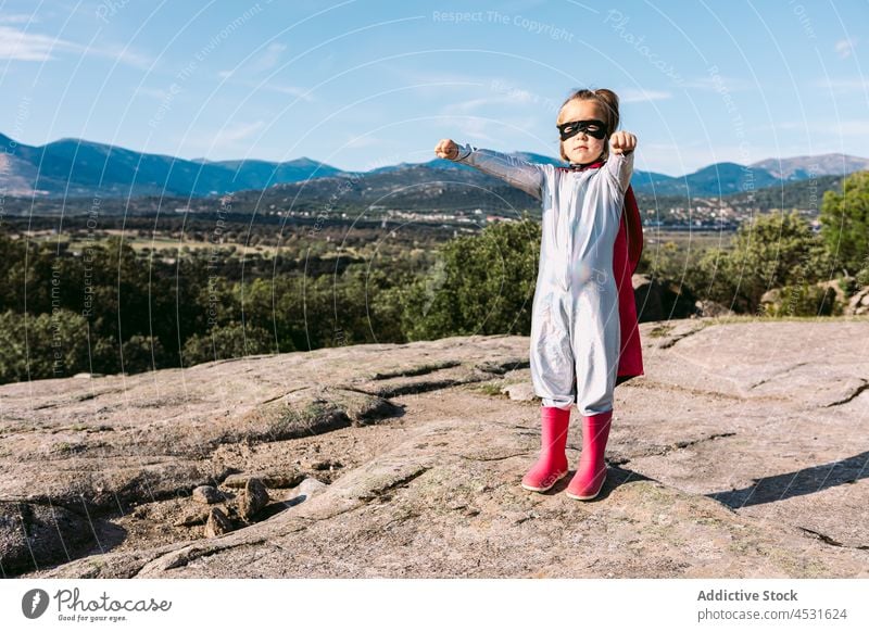 Brave kid in superhero costume showing fists girl child strong power courage pretend fearless gesture hill cape brave childhood strength protect cloak little