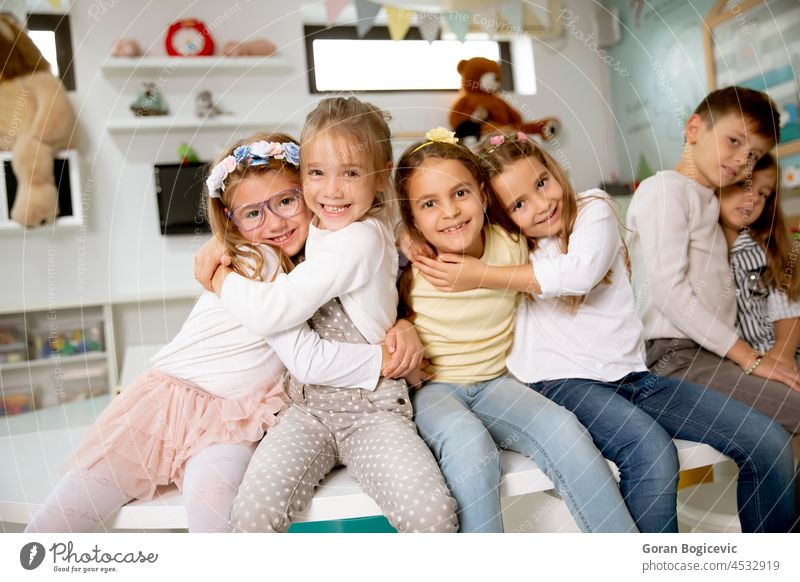 Group of kindergarten kid friends sitting and having fun young happy boy cute smile group childhood preschooler playroom lad children cheerful indoor little