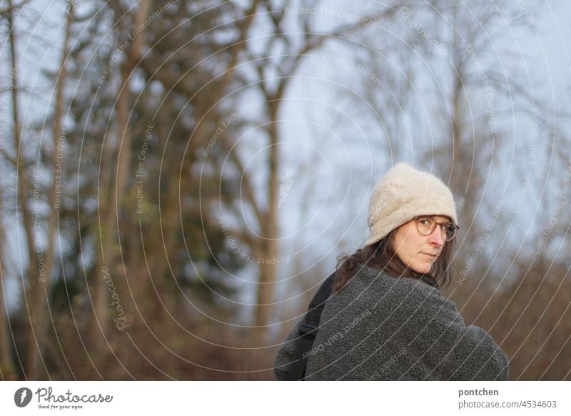 a woman in a cap and glasses looks back skeptically or annoyed. Review look back Exasperated skepticism Facial expression facial expression Aggravation