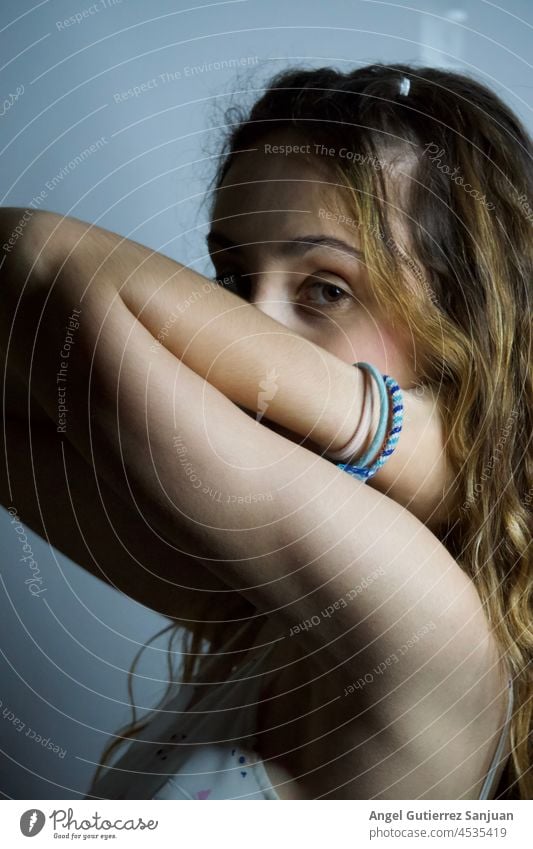 Woman looking at camera while posing with hands on her neck over an isolated background. woman pose arm studio studio shoot one person model young adult