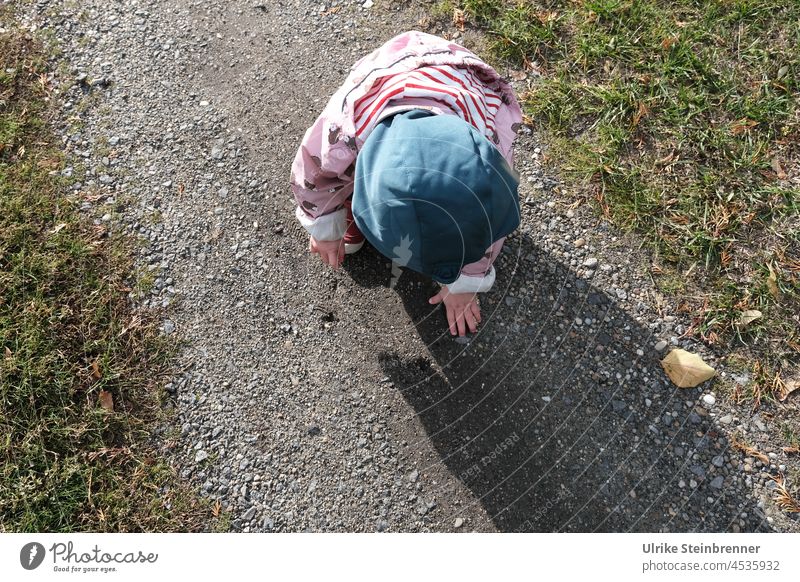 Toddler discovers things on a path Child off forest path pebbles stones Find search Discover Wonder joy of discovery Playing Infancy Nature Girl 1 - 3 years