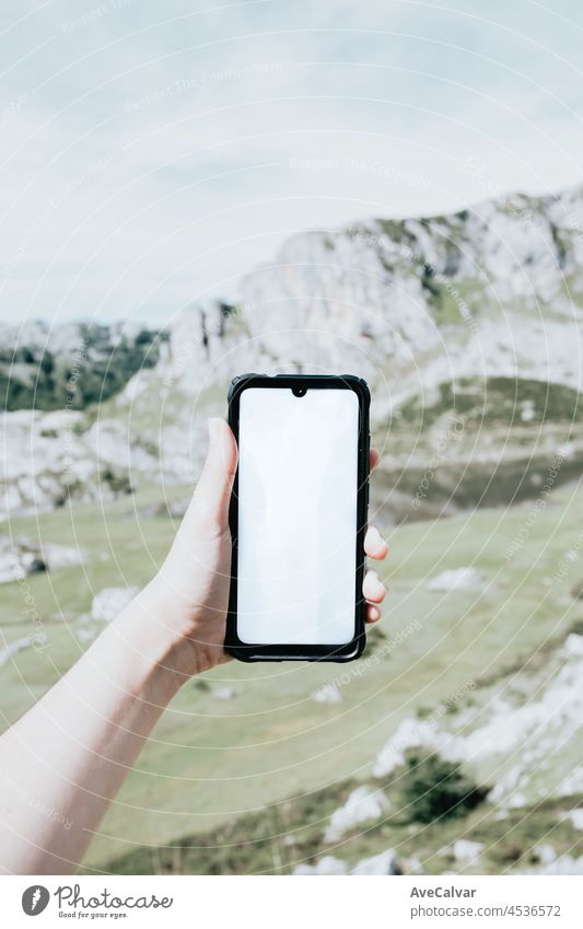 Moody wallpaper mobile phone with blank space, copy space in front of a colorful landscape of the mountains of Asturias during a sunny day, Covadonga lakes, peaceful scenario, snowy mountains, copy space