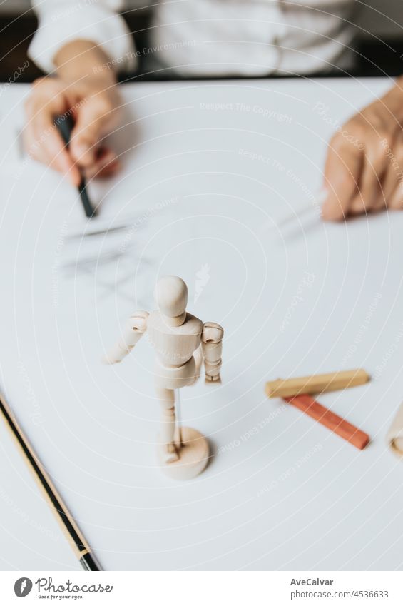 High angle view of a senior Caucasian woman drawing sketches in studio. Creativity, education and people concept,cognitive functions clock drawing self assessment test at home with positive results