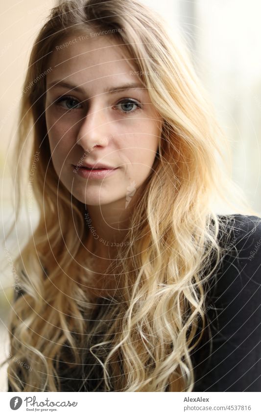 Portrait of a young, slim woman with long blond hair in the living room in front of the window Woman Young woman Large Blonde Long-haired pretty daintily Slim