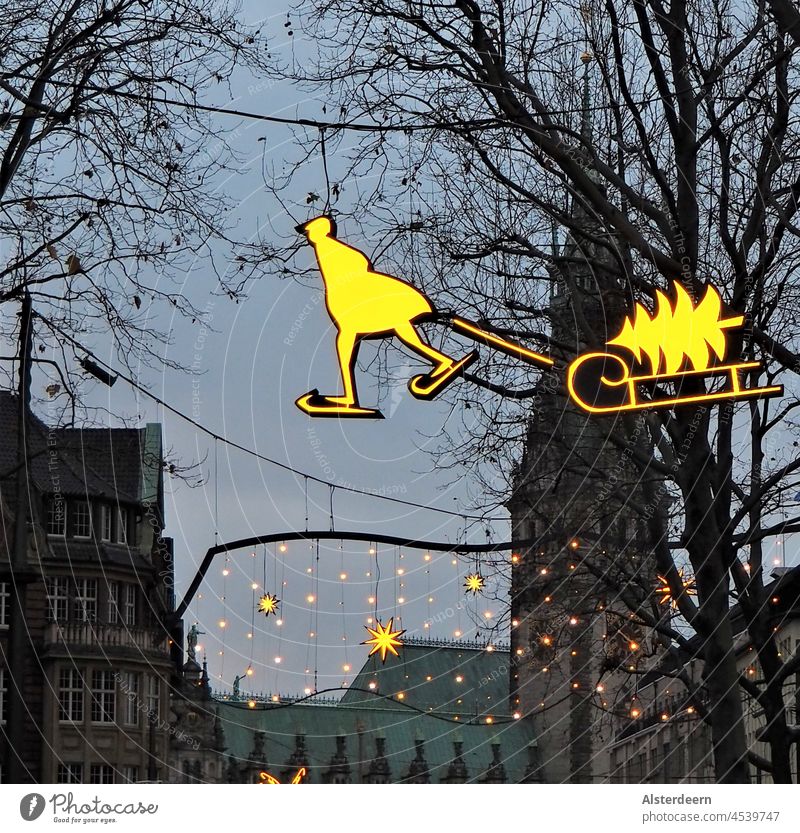 Winter lights skater with sledge and fir tree hovering over the shopping street in Hamburg in front of the town hall Winter lighting Skaters Sleigh Illuminate