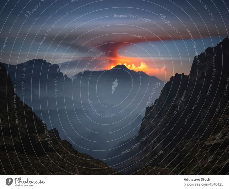 Steaming volcano in wild rocky valley under sunset sky mountain erupt silhouette landscape nature ridge highland island picturesque starry spectacular sundown