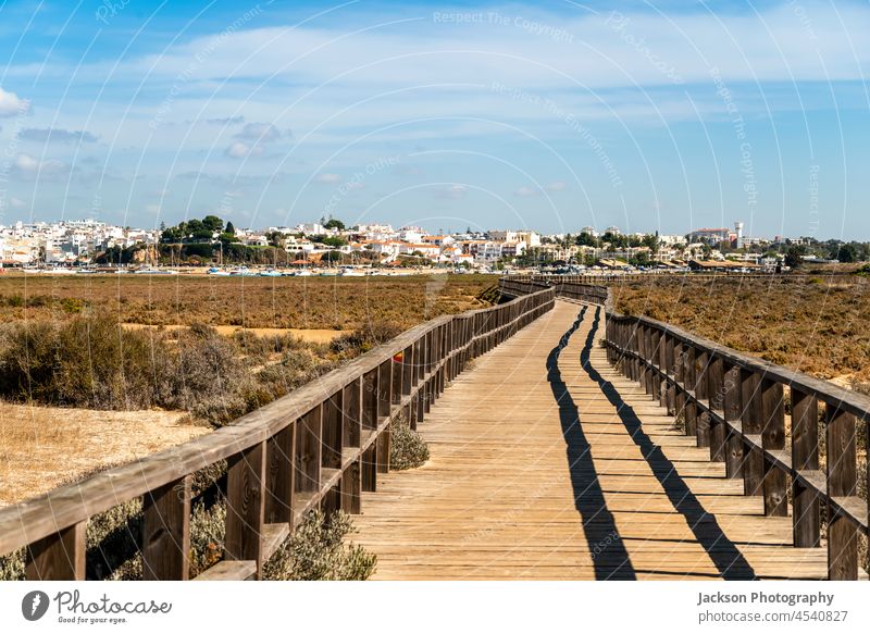 Wooden boardwalks by the coast of Alvor, Algarve, Portugal algarve alvor walkway nature wooden boat yacht harbor marina portugal architecture town cityscape