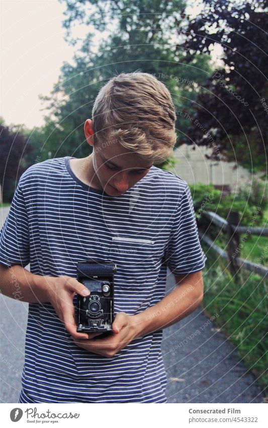 Young boy in the country taking a picture with an old vintage camera Camera Photography Travel Adventure Country Creative Vintage Antiques Tan Boy Man Inspired