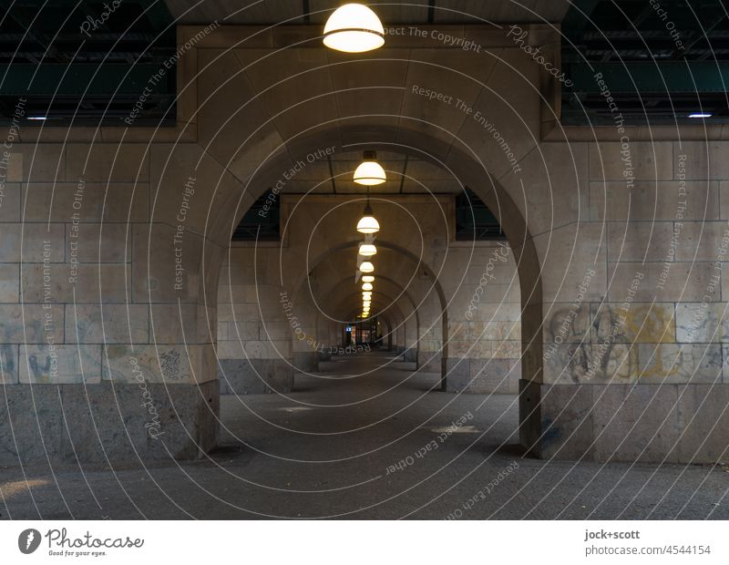 Underneath the elevated train, all the lights are on and there is not a person in sight. Eberswalder Street Schönhauser Allee Mono rail Passage Underpass