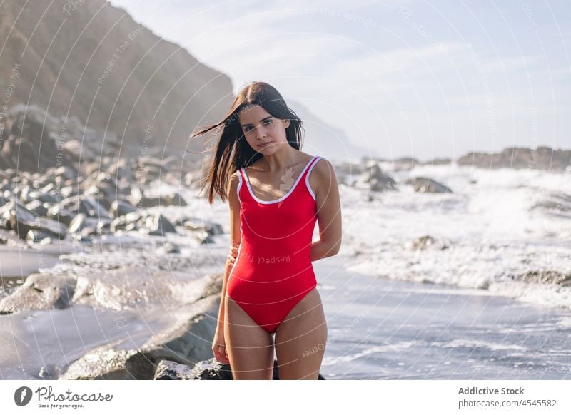 Woman in swimsuit near waving sea woman water swimwear coast shore coastal nature adventure pastime trip formation leisure environment seaside beach seashore