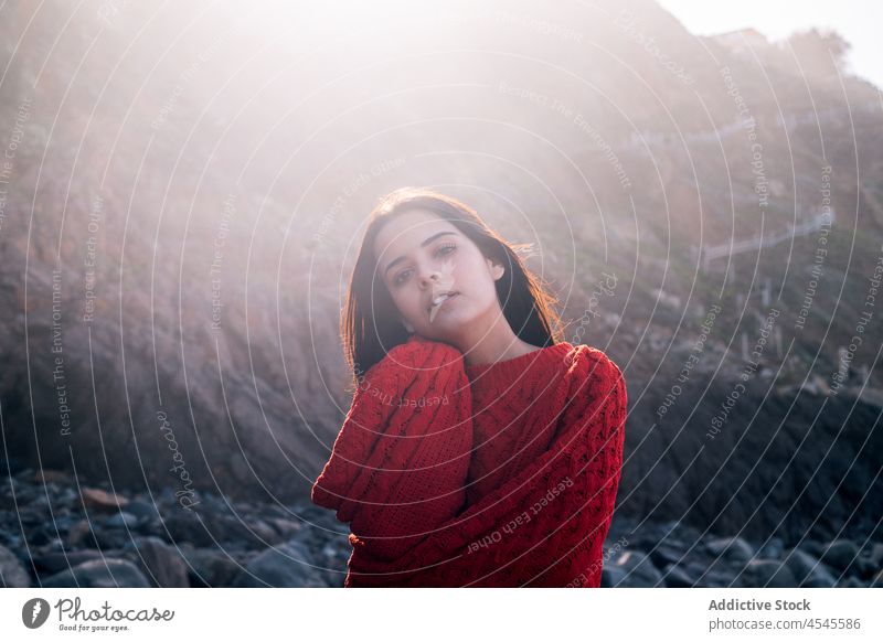 Positive woman on rocky coast shore coastal nature cliff adventure pastime trip stone formation leisure rough environment seaside beach seashore waterfront