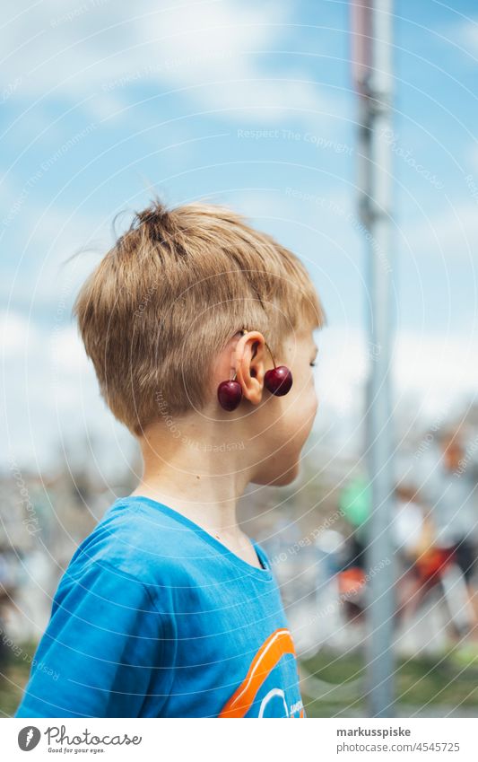 Child with cherry on ear Boy (child) Children's game children Infancy fun muck about Funster Comical Cherry cherries Ear Earring attach