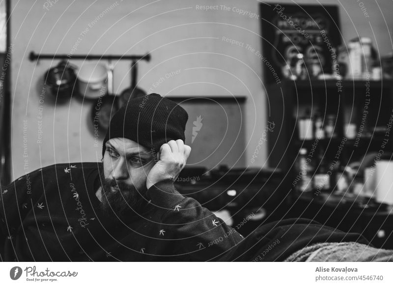 bored at home Portrait photograph man beard man with a beard watching sitting boredom looking bored human portrait face black and white indoors